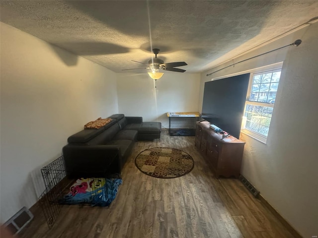 living room with ceiling fan, hardwood / wood-style flooring, and a textured ceiling