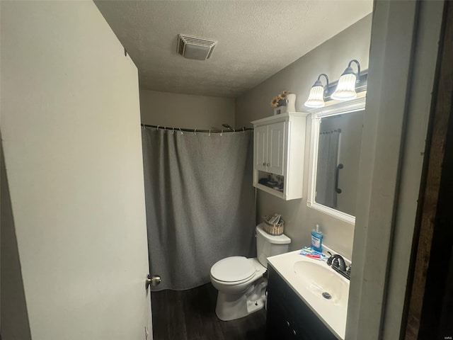 bathroom with hardwood / wood-style floors, vanity, toilet, a textured ceiling, and a shower with shower curtain