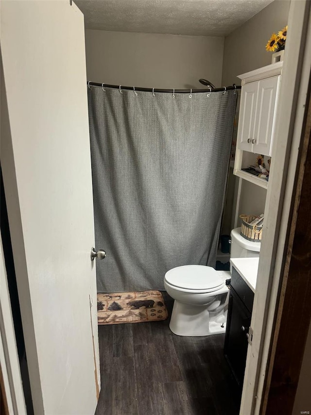 bathroom with vanity, hardwood / wood-style flooring, toilet, and a textured ceiling