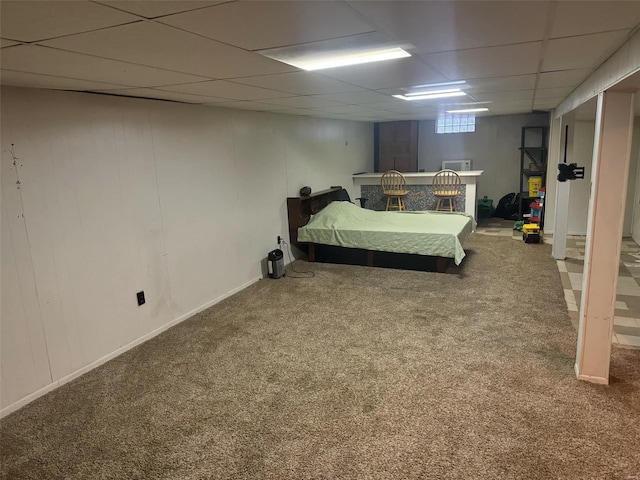 unfurnished bedroom featuring a drop ceiling and carpet flooring