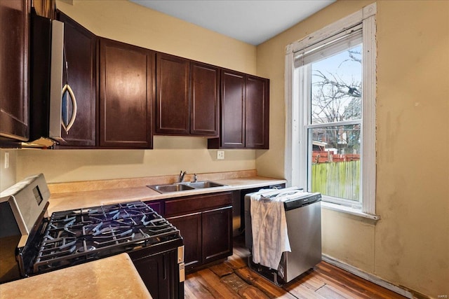 kitchen with gas range, wood-type flooring, sink, and a wealth of natural light