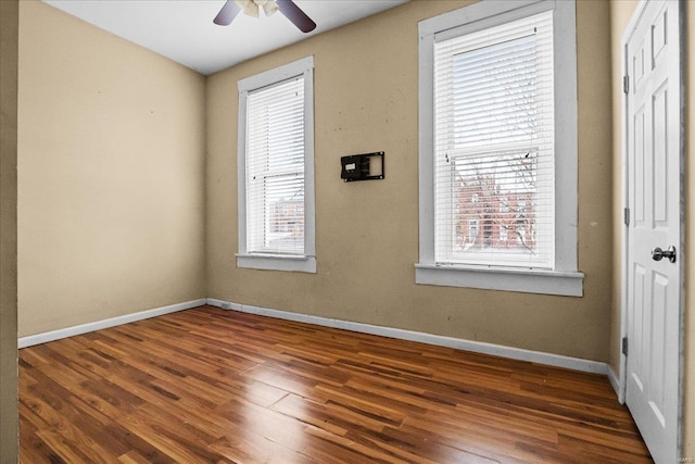 unfurnished room with dark wood-type flooring and ceiling fan