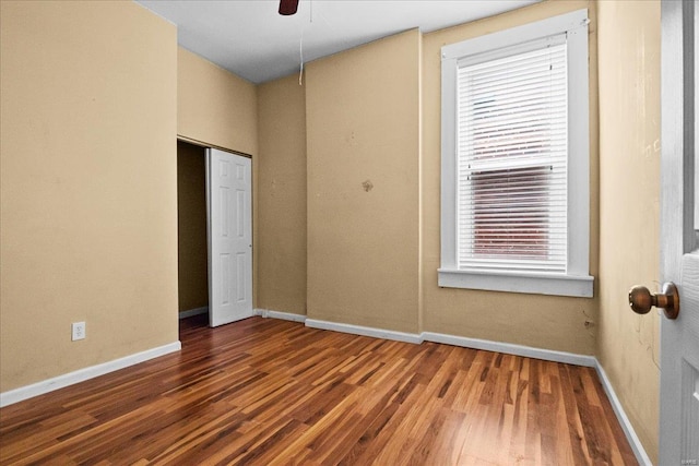 unfurnished bedroom featuring ceiling fan, wood-type flooring, and a closet