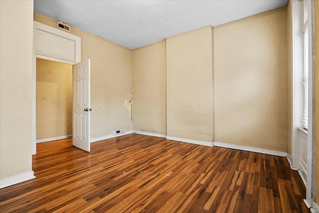 unfurnished room with dark wood-type flooring