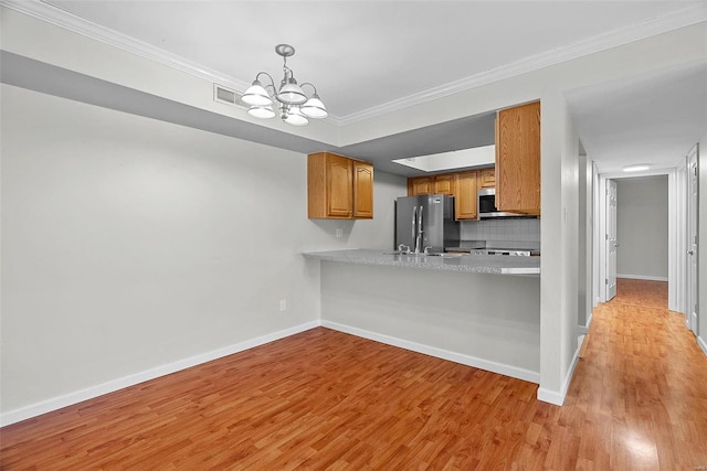 kitchen with ornamental molding, stainless steel appliances, kitchen peninsula, and light wood-type flooring