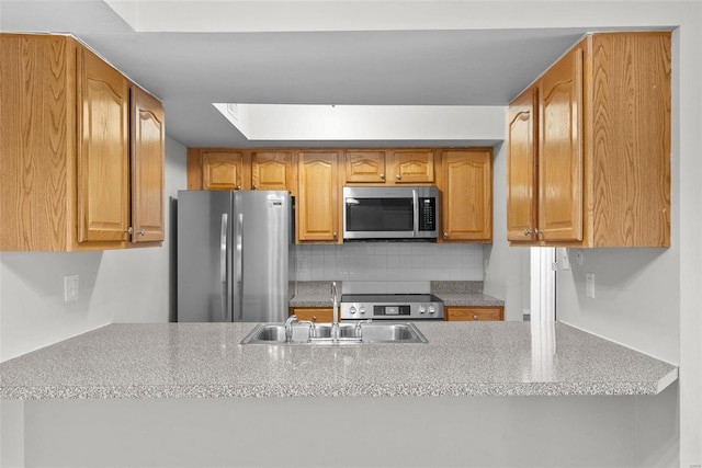 kitchen featuring a skylight, appliances with stainless steel finishes, sink, and decorative backsplash