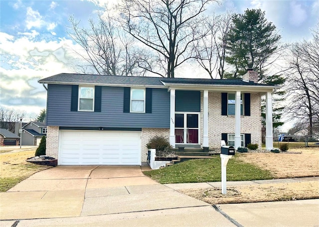 split foyer home featuring a garage and a front yard