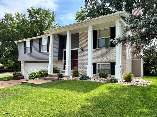 split foyer home featuring a garage and a front lawn