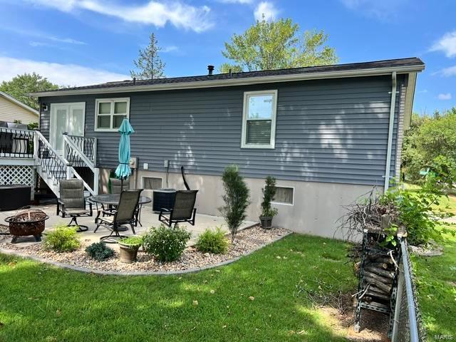 rear view of house with a yard, a patio area, and an outdoor fire pit