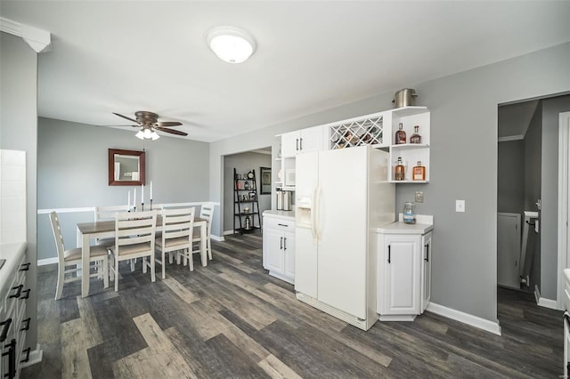 kitchen featuring white cabinetry, white fridge with ice dispenser, ceiling fan, and dark hardwood / wood-style floors