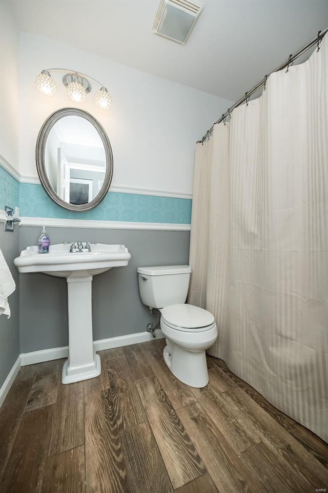 bathroom featuring hardwood / wood-style floors, toilet, and walk in shower