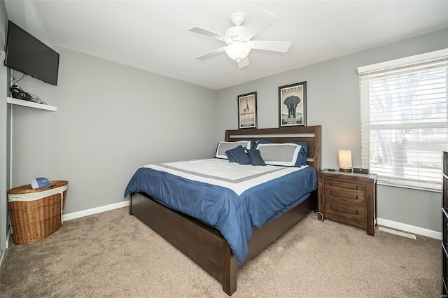 bedroom featuring multiple windows, light colored carpet, and ceiling fan