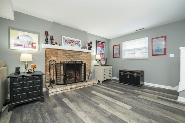 living room featuring dark wood-type flooring and a fireplace