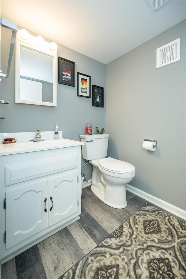 bathroom featuring hardwood / wood-style flooring, vanity, and toilet