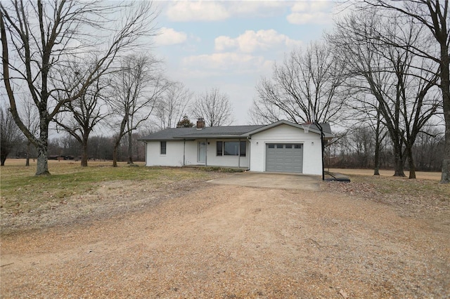 view of front of home featuring driveway, a garage, and a chimney