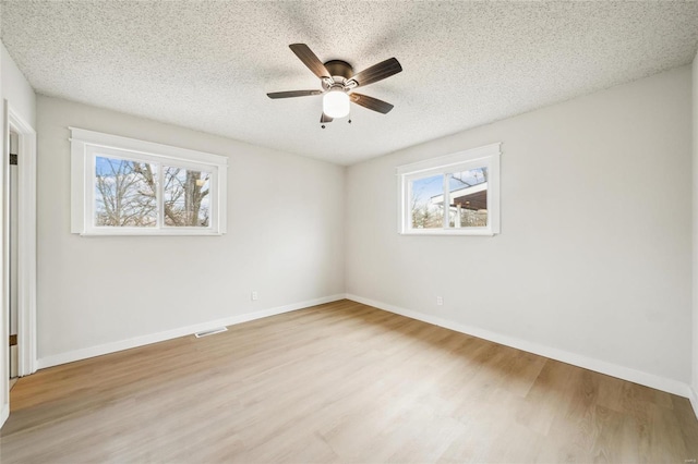 unfurnished room with ceiling fan, a textured ceiling, and light hardwood / wood-style floors