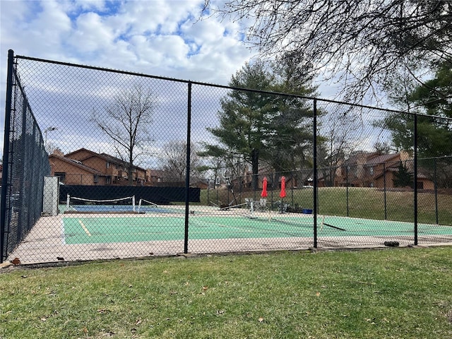 view of tennis court featuring a lawn