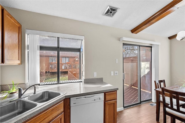 kitchen featuring sink, a wealth of natural light, a textured ceiling, and white dishwasher