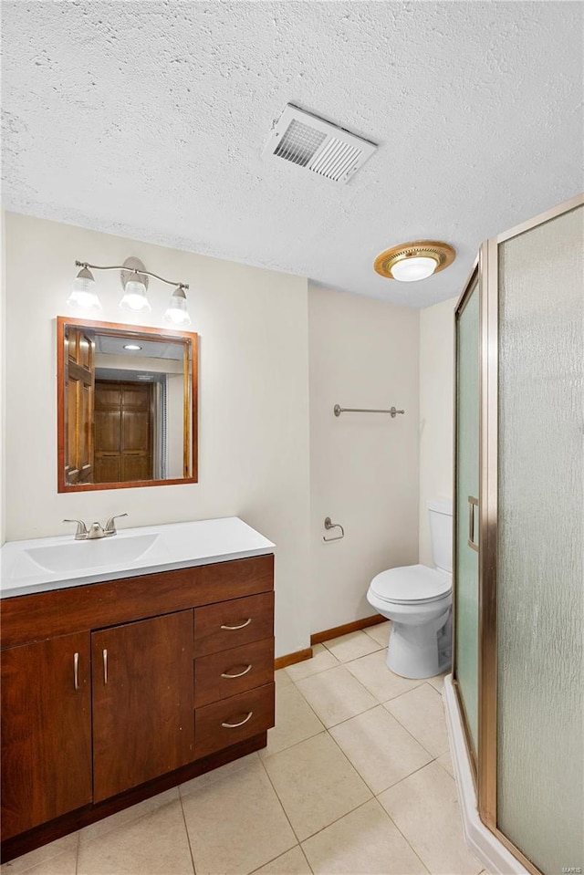 bathroom featuring a shower with door, vanity, tile patterned floors, and a textured ceiling