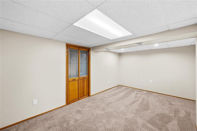 basement featuring carpet and a paneled ceiling