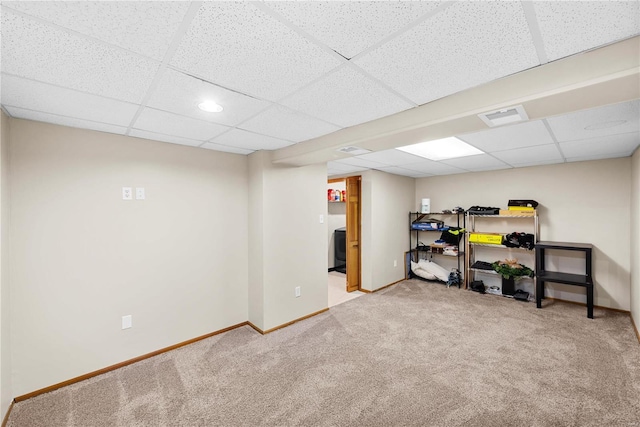 basement with light colored carpet and a drop ceiling