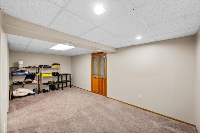 basement featuring a drop ceiling and carpet flooring