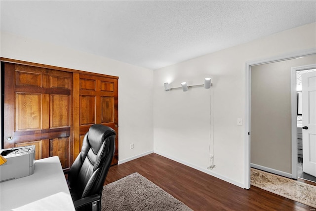 office area with dark wood-type flooring and a textured ceiling