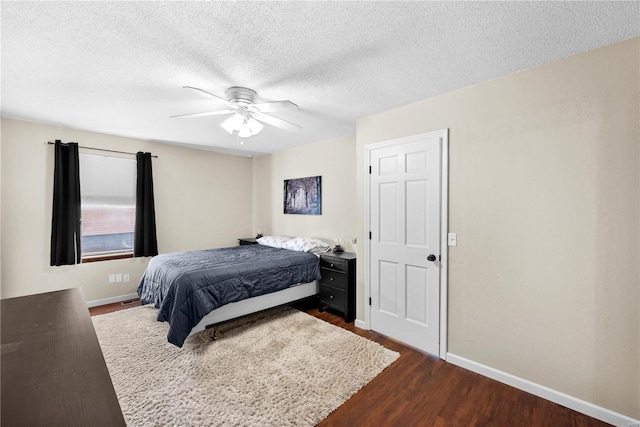 bedroom with ceiling fan, dark wood-type flooring, and a textured ceiling