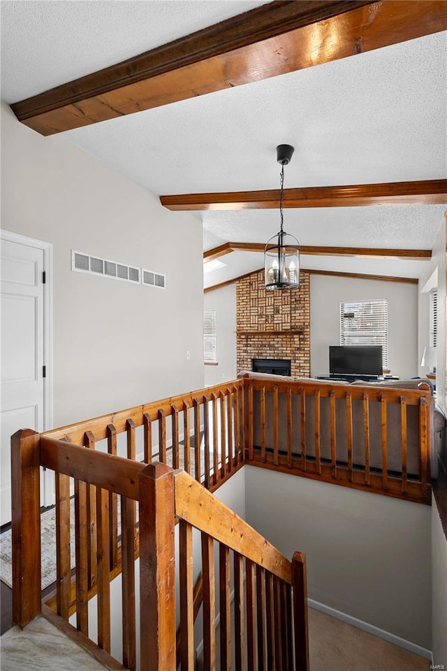 stairway with carpet floors, lofted ceiling with beams, a chandelier, and a textured ceiling