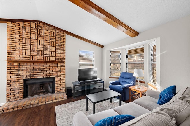 living room with vaulted ceiling with beams, a textured ceiling, dark hardwood / wood-style floors, and a brick fireplace