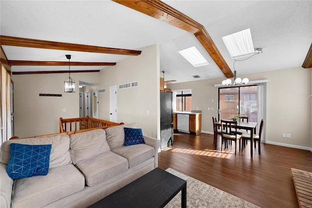 living room with an inviting chandelier, dark hardwood / wood-style floors, and lofted ceiling with skylight