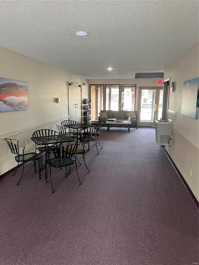 carpeted dining area featuring a textured ceiling