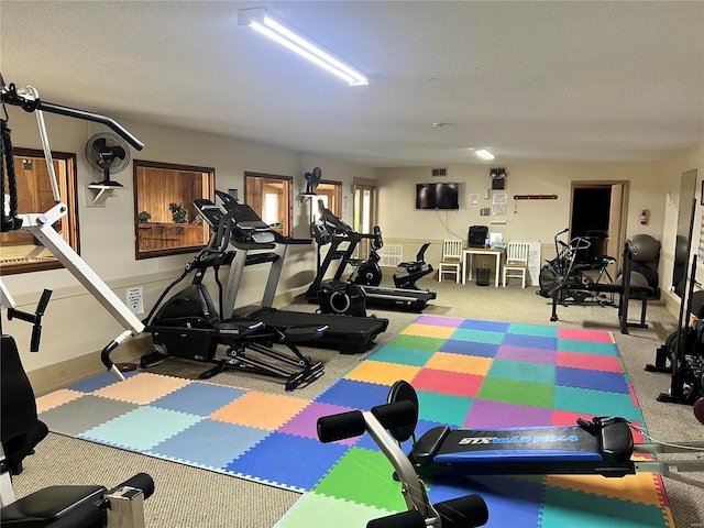 exercise room with carpet flooring and a textured ceiling