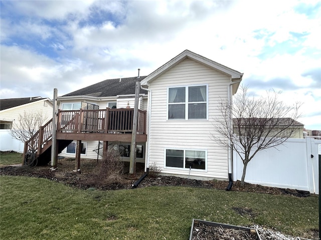 rear view of property featuring a wooden deck and a lawn