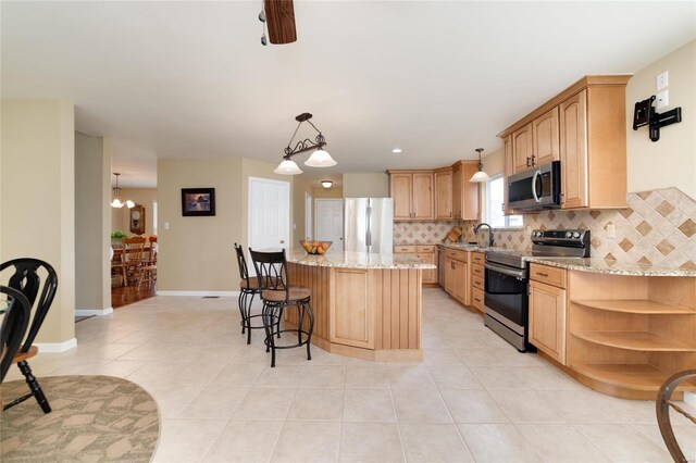 kitchen featuring pendant lighting, appliances with stainless steel finishes, a center island, light tile patterned flooring, and decorative backsplash