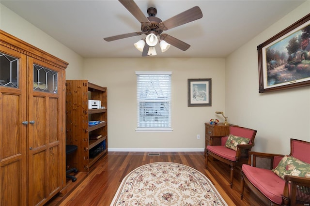 living area with dark hardwood / wood-style floors and ceiling fan