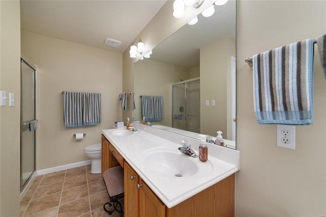 bathroom featuring a shower with door, vanity, tile patterned flooring, and toilet