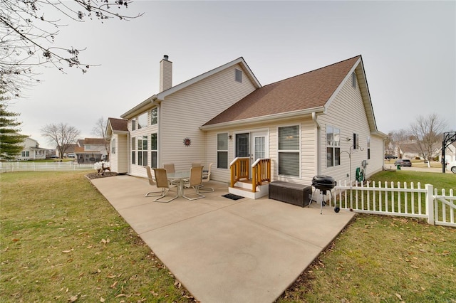 rear view of house with a lawn and a patio area