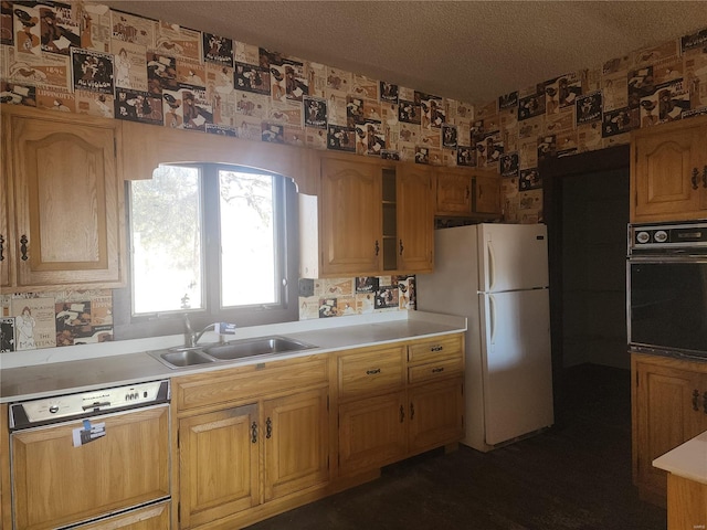 kitchen featuring sink, a textured ceiling, white refrigerator, dishwasher, and oven