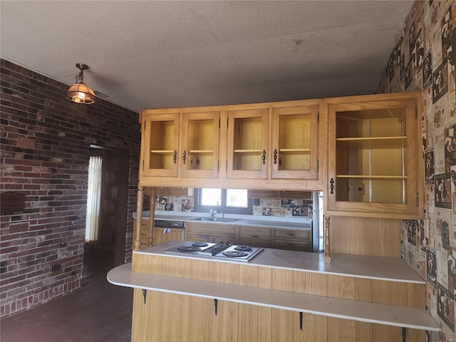 kitchen featuring dishwasher, stainless steel gas cooktop, a kitchen bar, and kitchen peninsula