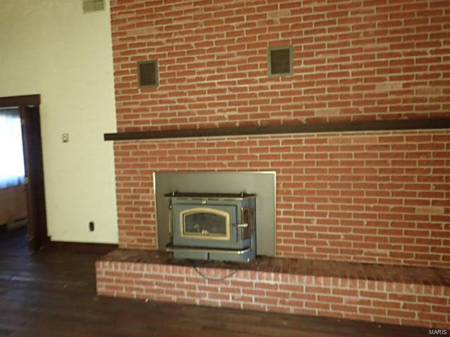 details featuring wood-type flooring and a wood stove