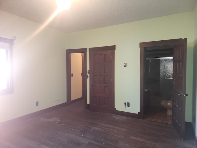 unfurnished bedroom with dark hardwood / wood-style floors and a textured ceiling