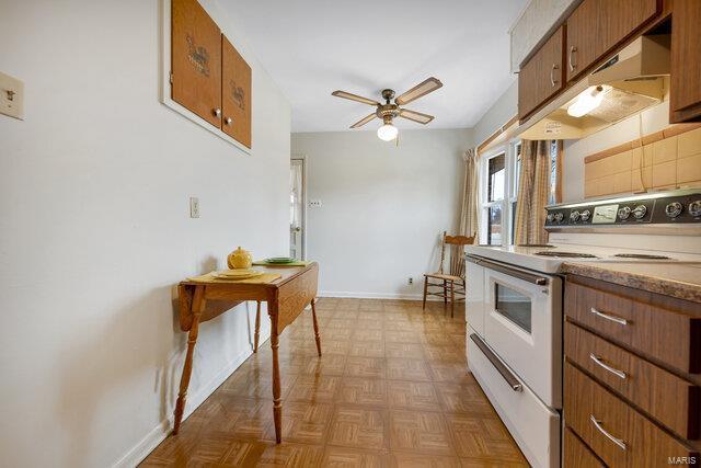 kitchen with ceiling fan, white electric range, light parquet flooring, and backsplash