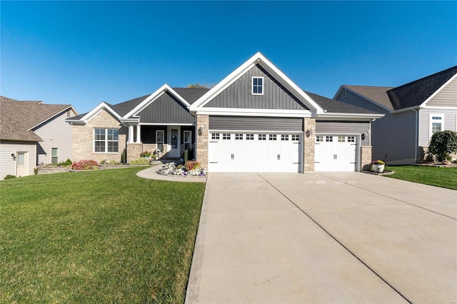 craftsman inspired home featuring a garage and a front lawn