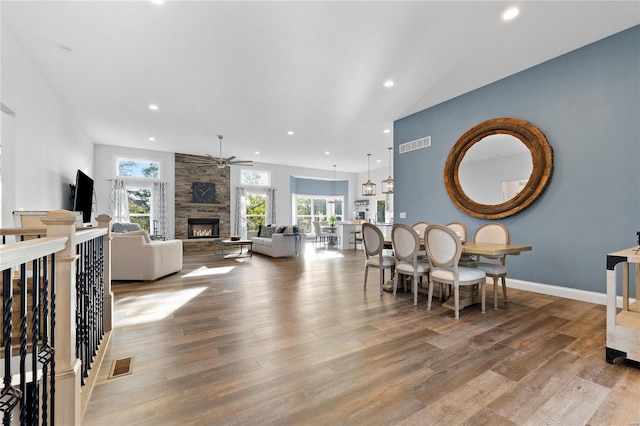 dining space with ceiling fan, a fireplace, and light hardwood / wood-style floors