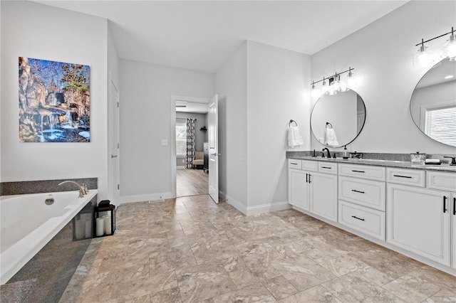 bathroom featuring a relaxing tiled tub and vanity