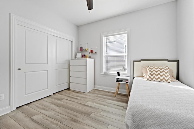 bedroom featuring light hardwood / wood-style floors, a closet, and ceiling fan