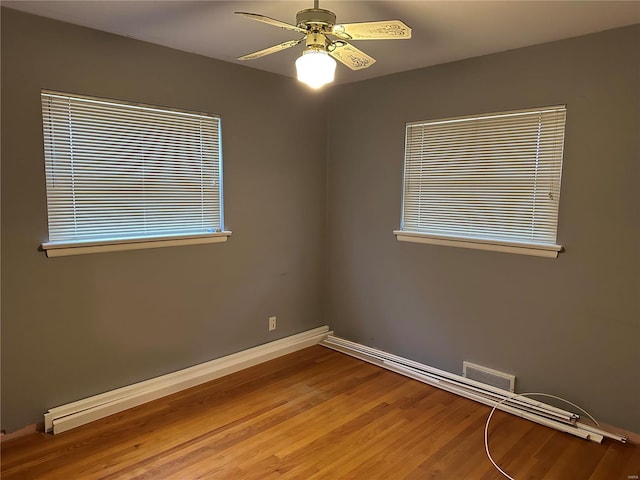 spare room featuring a healthy amount of sunlight, ceiling fan, and light wood-type flooring