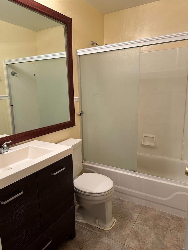 full bathroom featuring bath / shower combo with glass door, vanity, toilet, and tile patterned flooring