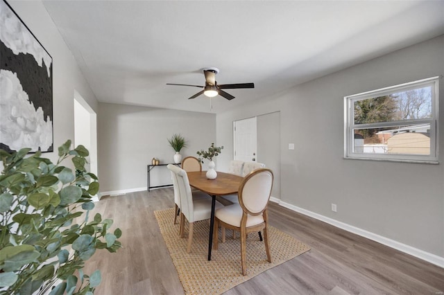 dining space featuring light wood-type flooring, ceiling fan, and baseboards